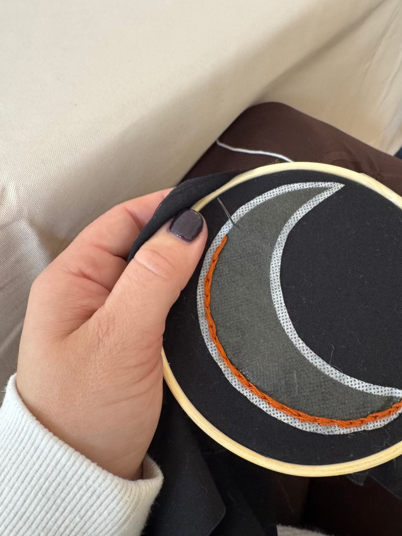 Hand embroidery workshop with participant holding an embroidery piece.